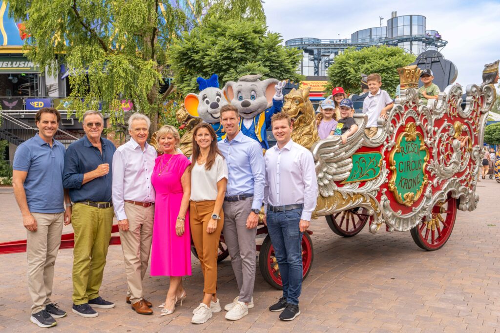 Die Inhaberfamilie Mack mit Thomas, Roland, Jürgen, Mauritia, Ann-Kathrin, Nicolas und Frederik vor dem über 100 Jahre alten, prachtvoll verzierten, Zirkuswagen aus dem Hause Mack © Europa-Park GmbH & Co Mack KG