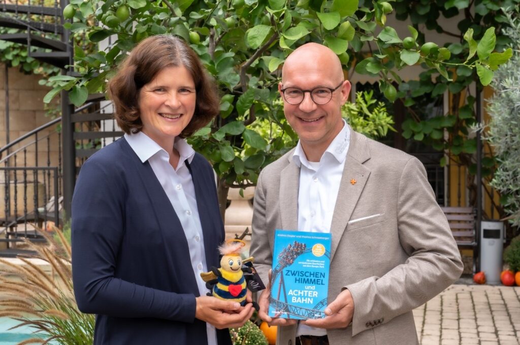 Andrea Ziegler und Thomas Schneeberger mit dem Buch „Zwischen Himmel und Achterbahn“ © Europa-Park GmbH & Co Mack KG